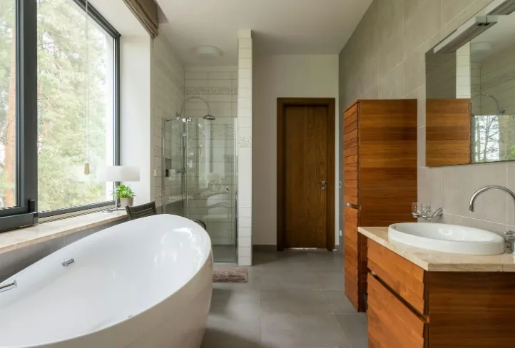 Baño con bañera exenta y muebles de madera, reforma en María de Huerva