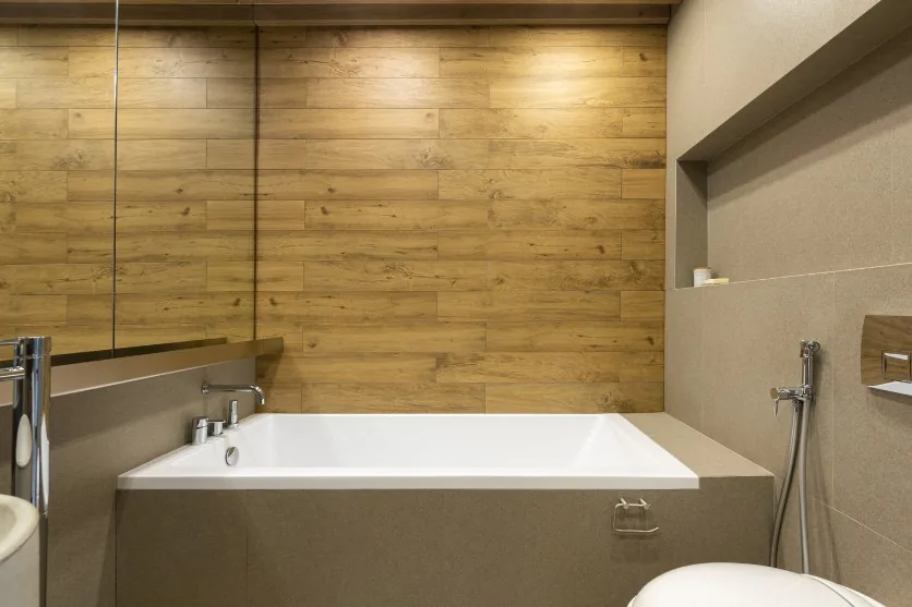 Baño con bañera y revestimiento efecto madera, reforma en Villanueva de Gállego