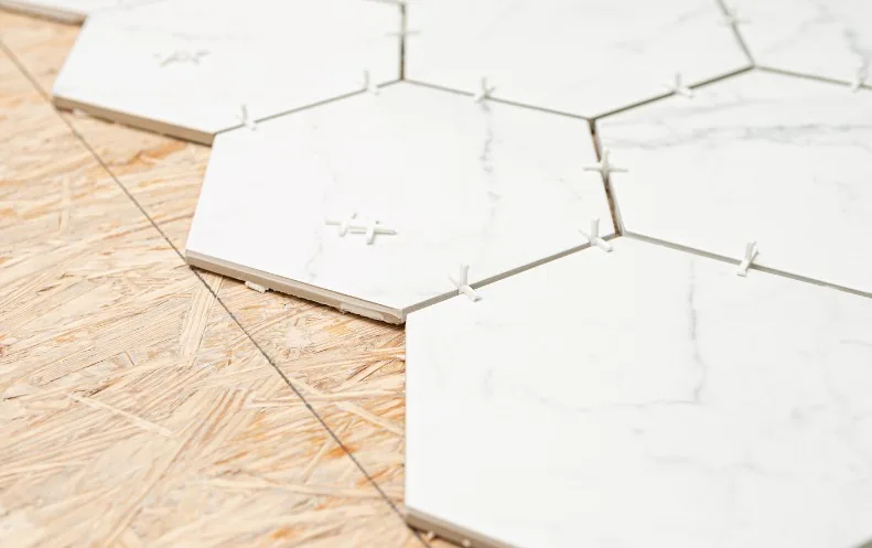 Colocación de azulejo hexagonal efecto mármol durante la obra