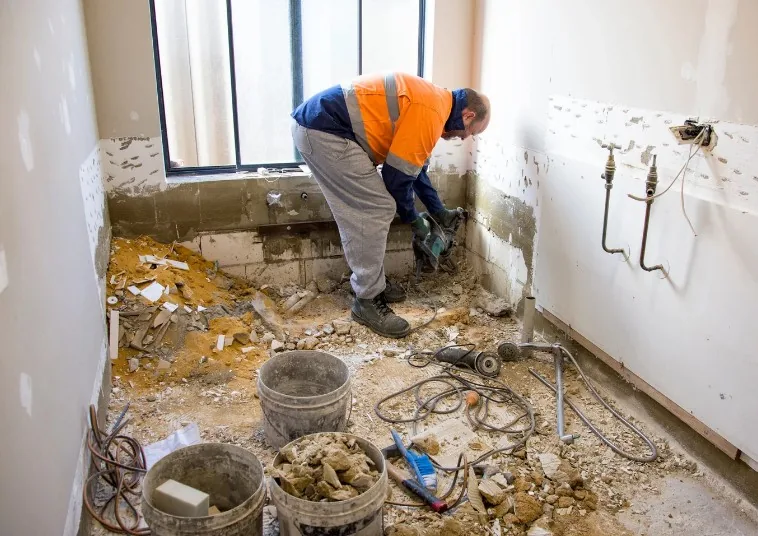 Baño vaciado por completo durante la obra, con las tuberías antiguas a la vista